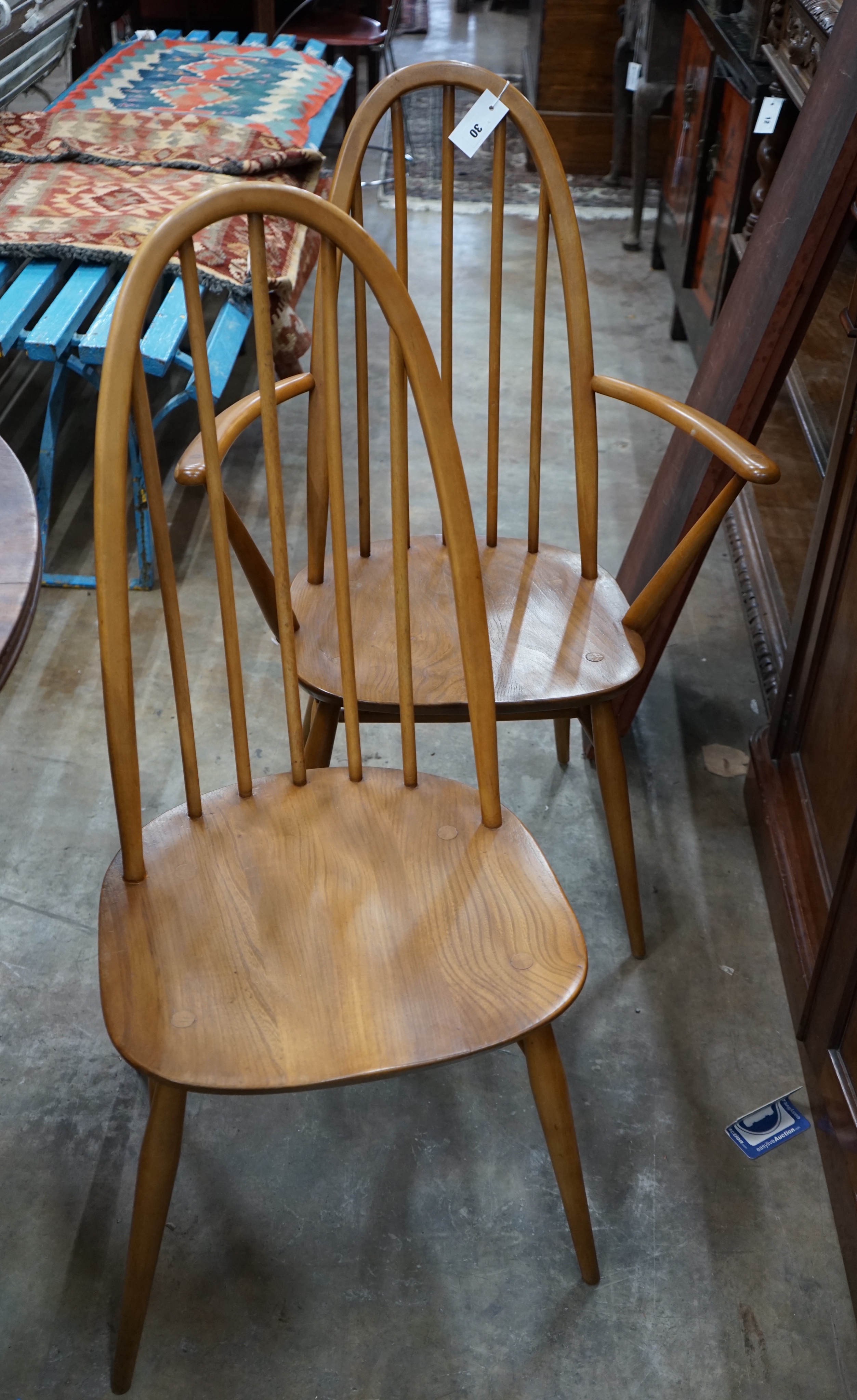A set of six Ercol elm and beech comb back dining chairs, two with arms